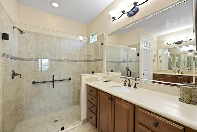 bathroom featuring walk in shower and vanity