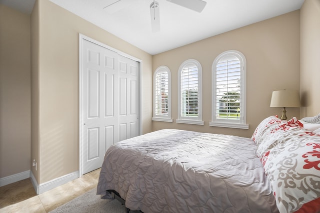 tiled bedroom featuring ceiling fan and a closet