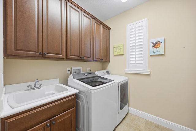 laundry area featuring cabinets, a textured ceiling, sink, light tile patterned flooring, and washer and dryer