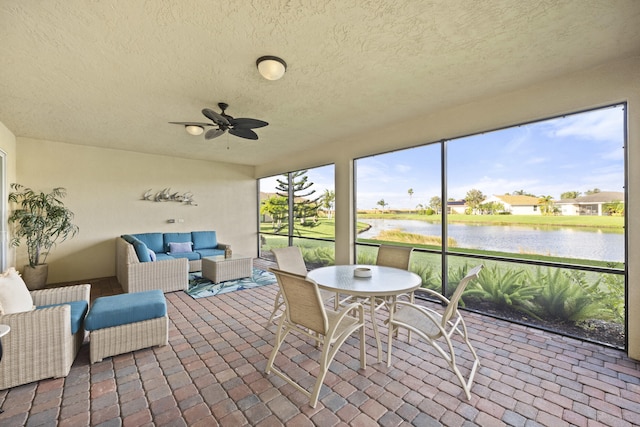 sunroom with a water view and ceiling fan