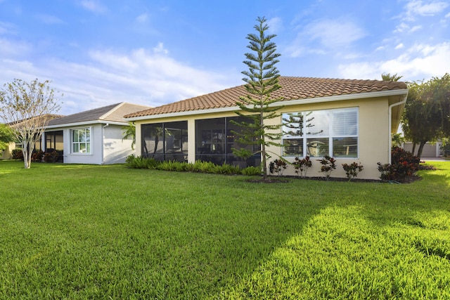 back of house featuring a sunroom and a yard