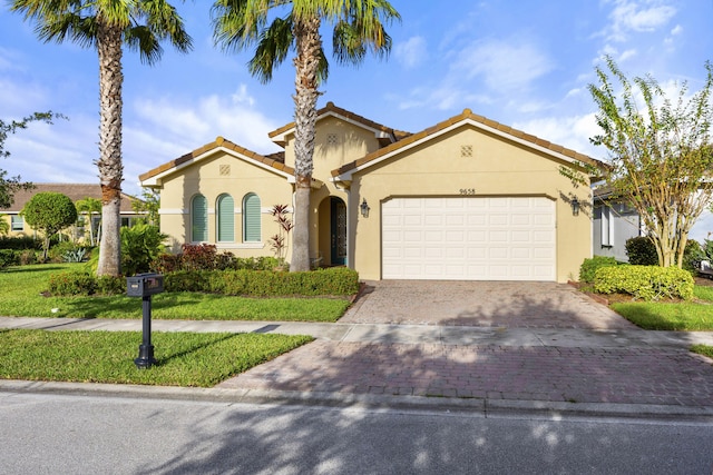 mediterranean / spanish home with a front lawn and a garage