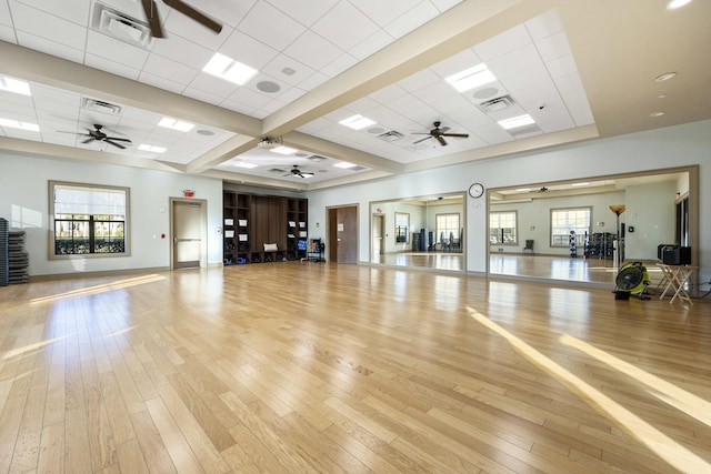 exercise room featuring a drop ceiling and light hardwood / wood-style floors