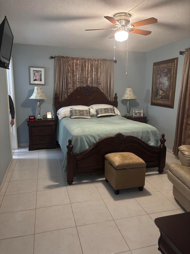 bedroom featuring a textured ceiling, light tile patterned floors, and ceiling fan