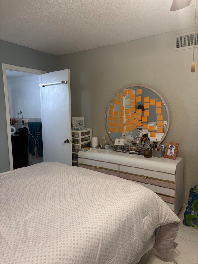 bedroom with a textured ceiling and tile patterned floors