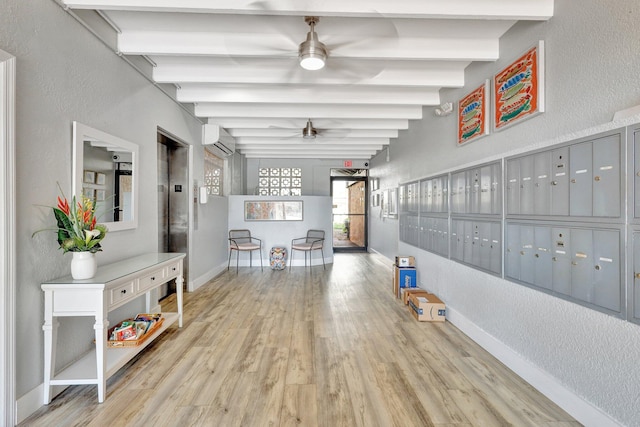 corridor with beam ceiling, elevator, a wall mounted air conditioner, mail boxes, and light wood-type flooring