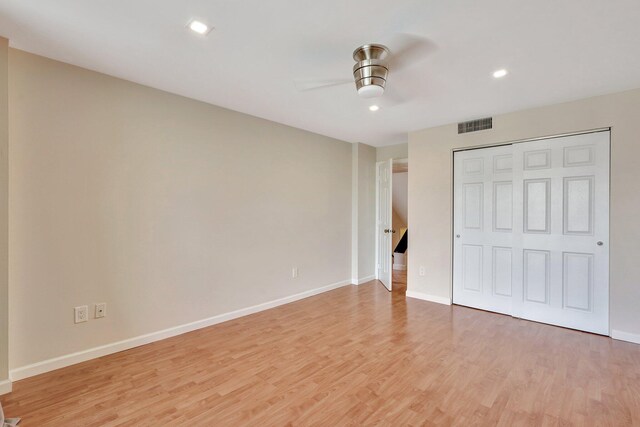 unfurnished bedroom featuring ceiling fan, a closet, and hardwood / wood-style flooring