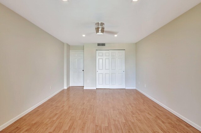 unfurnished bedroom featuring ceiling fan, light wood-type flooring, and a closet