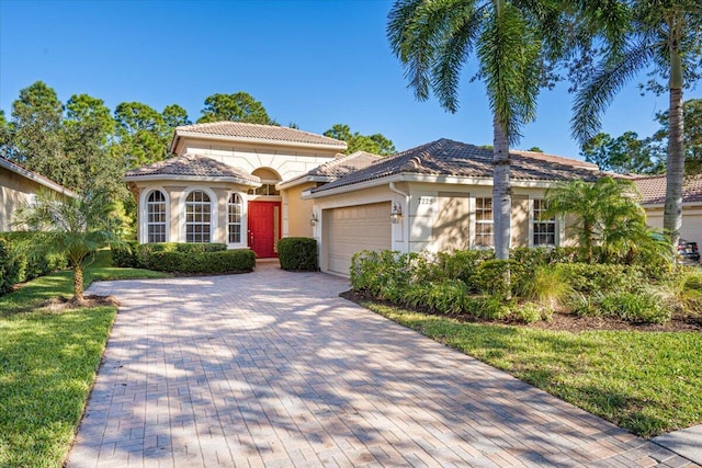 mediterranean / spanish-style house with a front lawn and a garage