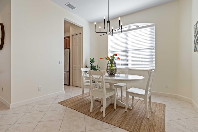 dining space featuring light tile patterned flooring and an inviting chandelier