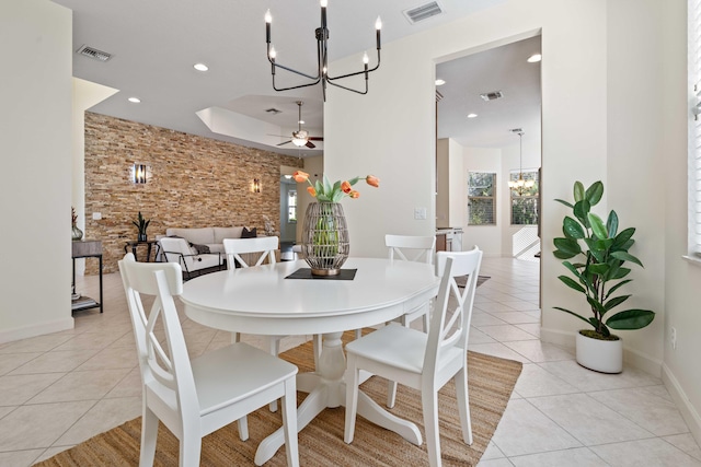 dining area with light tile patterned floors and ceiling fan with notable chandelier