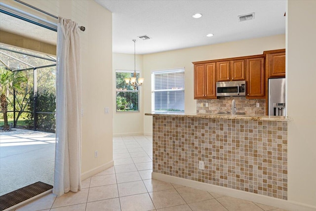 kitchen featuring sink, stainless steel appliances, backsplash, pendant lighting, and light tile patterned floors