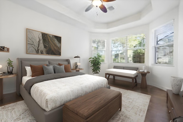 bedroom with a raised ceiling, ceiling fan, and hardwood / wood-style flooring