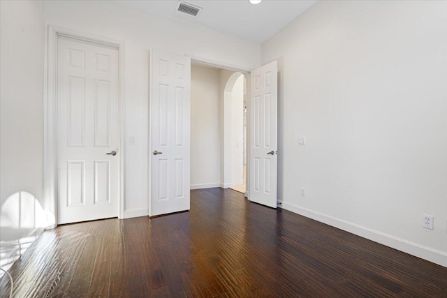 unfurnished bedroom with dark hardwood / wood-style flooring