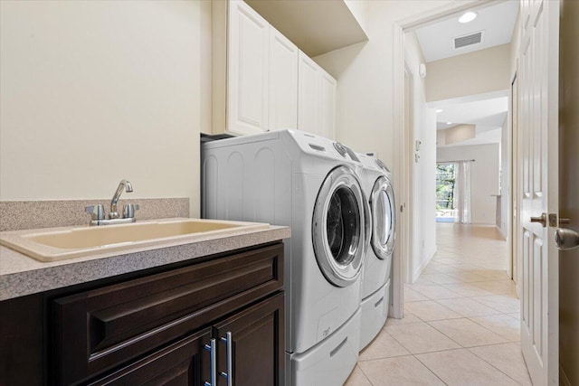 washroom featuring washer and clothes dryer, light tile patterned flooring, cabinets, and sink