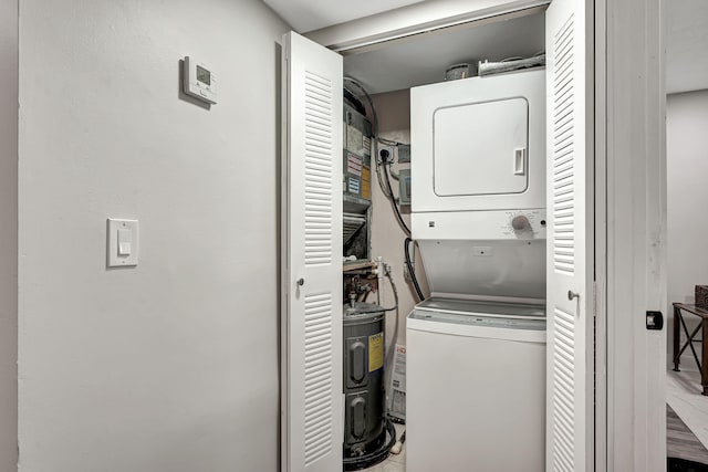 laundry area featuring water heater and stacked washer / dryer