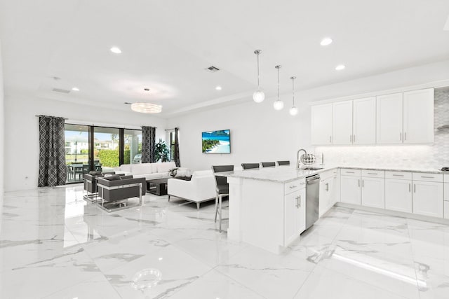 kitchen featuring pendant lighting, white cabinetry, dishwasher, a kitchen breakfast bar, and kitchen peninsula