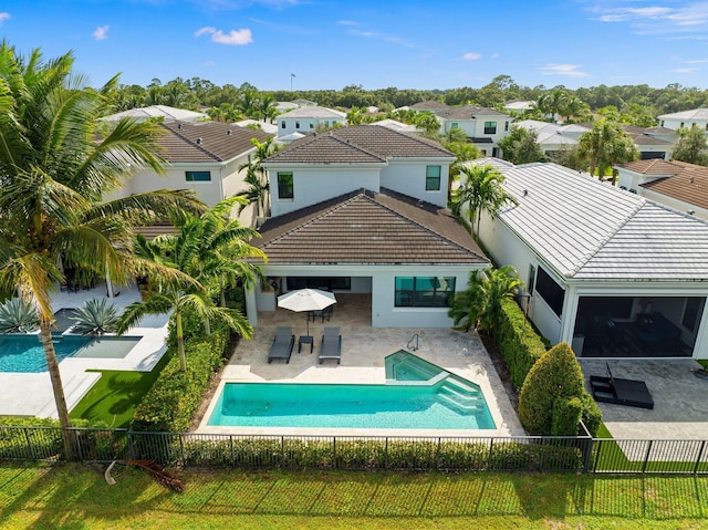 13689 Artisan Cir, Palm Beach Gardens, FL 33418 - back of house with a residential view, stucco siding, a fenced backyard, a tiled roof, and a fenced in pool