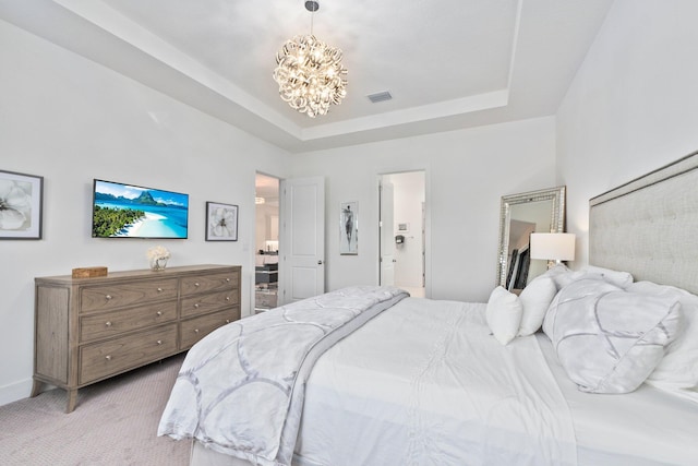 bedroom featuring light carpet, a notable chandelier, and a tray ceiling