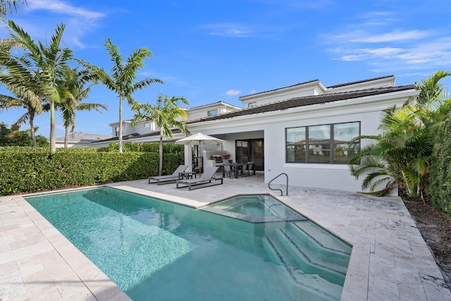 13689 Artisan Cir, Palm Beach Gardens, FL 33418 - rear view of property featuring a patio, a pool with connected hot tub, and stucco siding