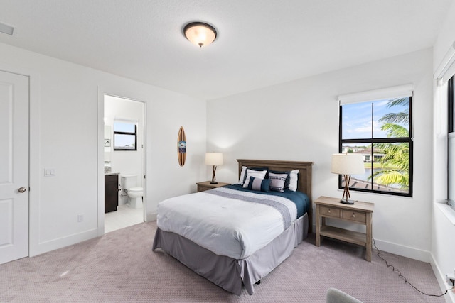 carpeted bedroom featuring ensuite bathroom