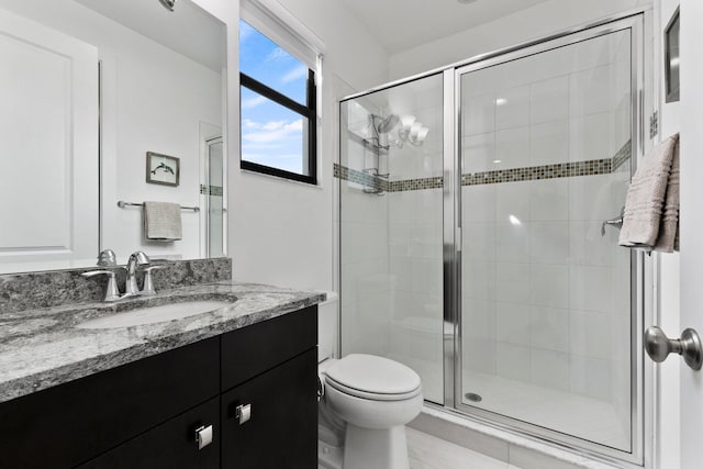 bathroom featuring an enclosed shower, vanity, and toilet