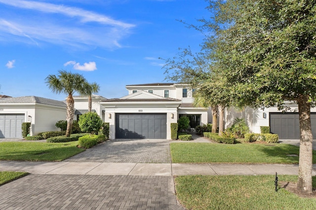 13689 Artisan Cir, Palm Beach Gardens, FL 33418 - view of front facade with an attached garage, stucco siding, decorative driveway, and a front yard