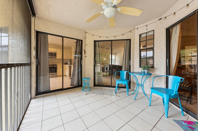 unfurnished sunroom with ceiling fan