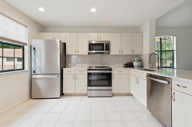 kitchen featuring tasteful backsplash, a wealth of natural light, sink, and stainless steel appliances