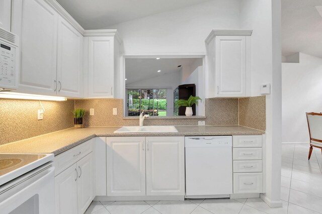 kitchen featuring white cabinetry, backsplash, sink, vaulted ceiling, and white appliances