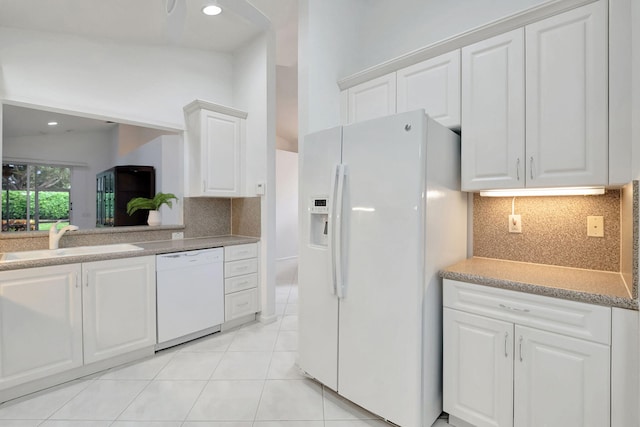 kitchen with white appliances, white cabinetry, and sink