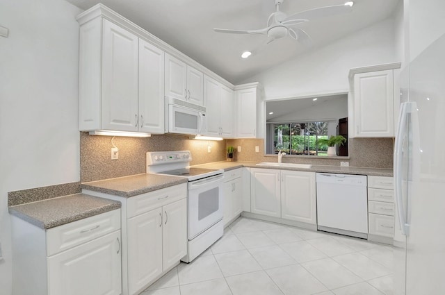 kitchen with white appliances, white cabinetry, sink, and lofted ceiling