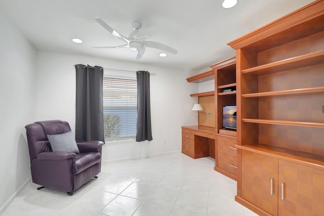 office with built in desk, ceiling fan, and light tile patterned floors