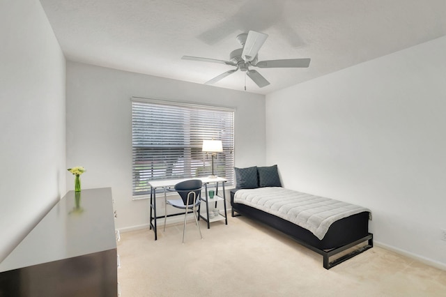 carpeted bedroom featuring ceiling fan and a textured ceiling