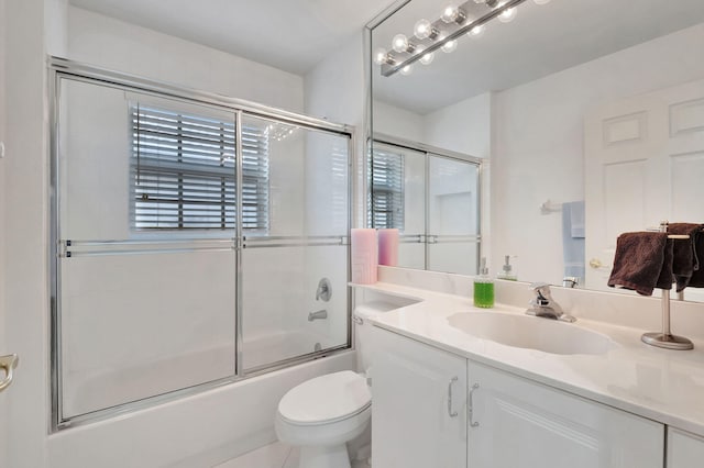 full bathroom featuring toilet, combined bath / shower with glass door, vanity, and tile patterned floors