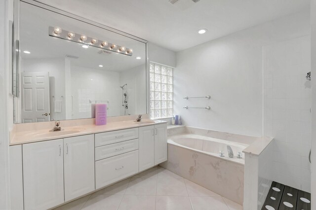 bathroom with tile patterned flooring, vanity, and plus walk in shower