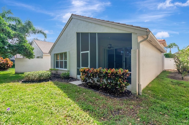 back of property with a sunroom and a yard