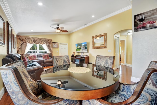 dining area with light wood-type flooring, vaulted ceiling, ceiling fan, and crown molding