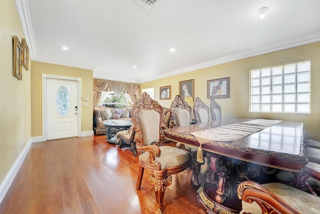 dining room with light hardwood / wood-style floors and crown molding