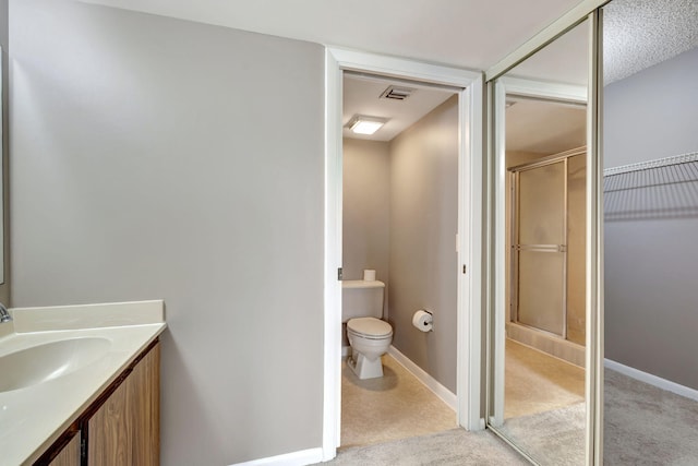 bathroom featuring walk in shower, vanity, and toilet