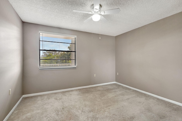 spare room featuring a textured ceiling, light carpet, and ceiling fan