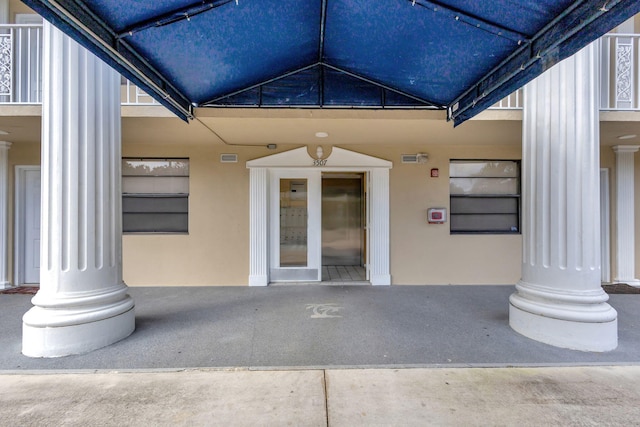 3507 Village Blvd Unit 305, West Palm Beach, FL 33409 - view of exterior entry with stucco siding