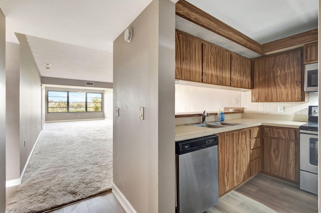 3507 Village Blvd Unit 305, West Palm Beach, FL 33409 - kitchen featuring appliances with stainless steel finishes, light countertops, carpet flooring, and open floor plan