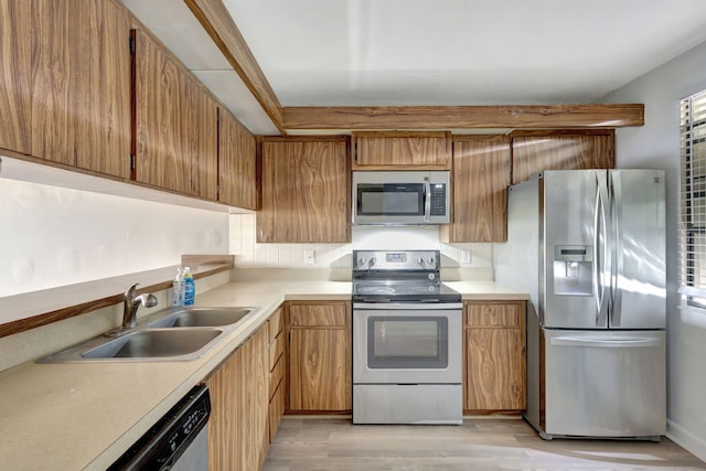 kitchen with light wood-type flooring, appliances with stainless steel finishes, and sink