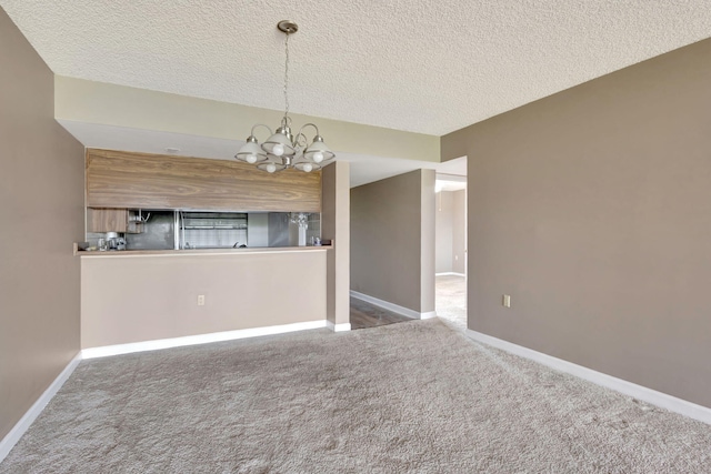 interior space featuring an inviting chandelier, carpet flooring, and a textured ceiling