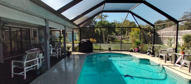 view of swimming pool featuring glass enclosure and a patio area