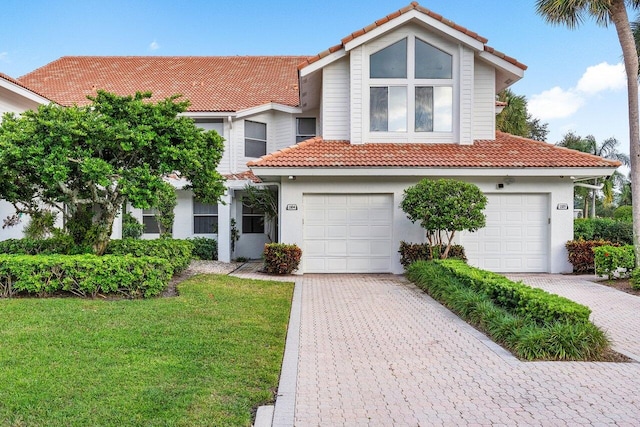 mediterranean / spanish home with a front lawn and a garage