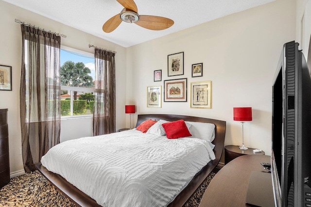 bedroom with ceiling fan and a textured ceiling