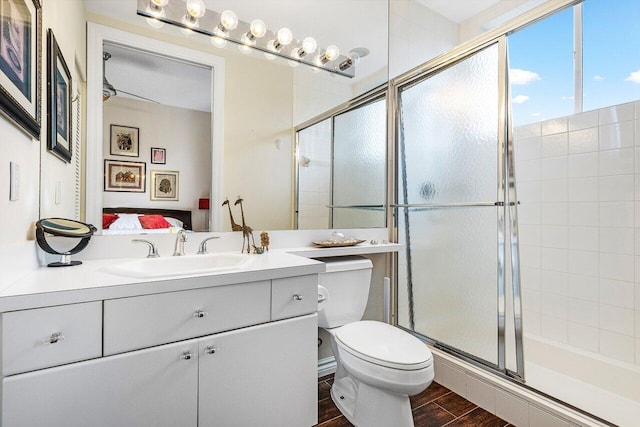 bathroom featuring hardwood / wood-style floors, vanity, toilet, and a shower with shower door