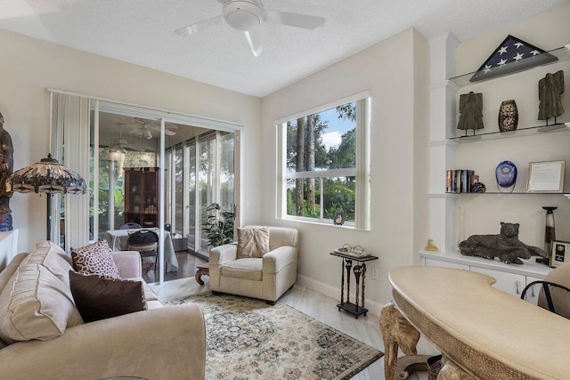 sitting room with a textured ceiling, light hardwood / wood-style floors, and ceiling fan